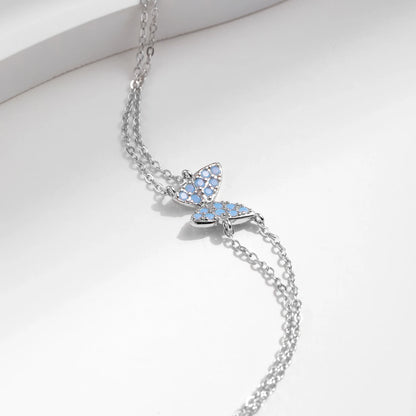 Delicate silver bracelet with a central opal butterfly charm and fine double chain

