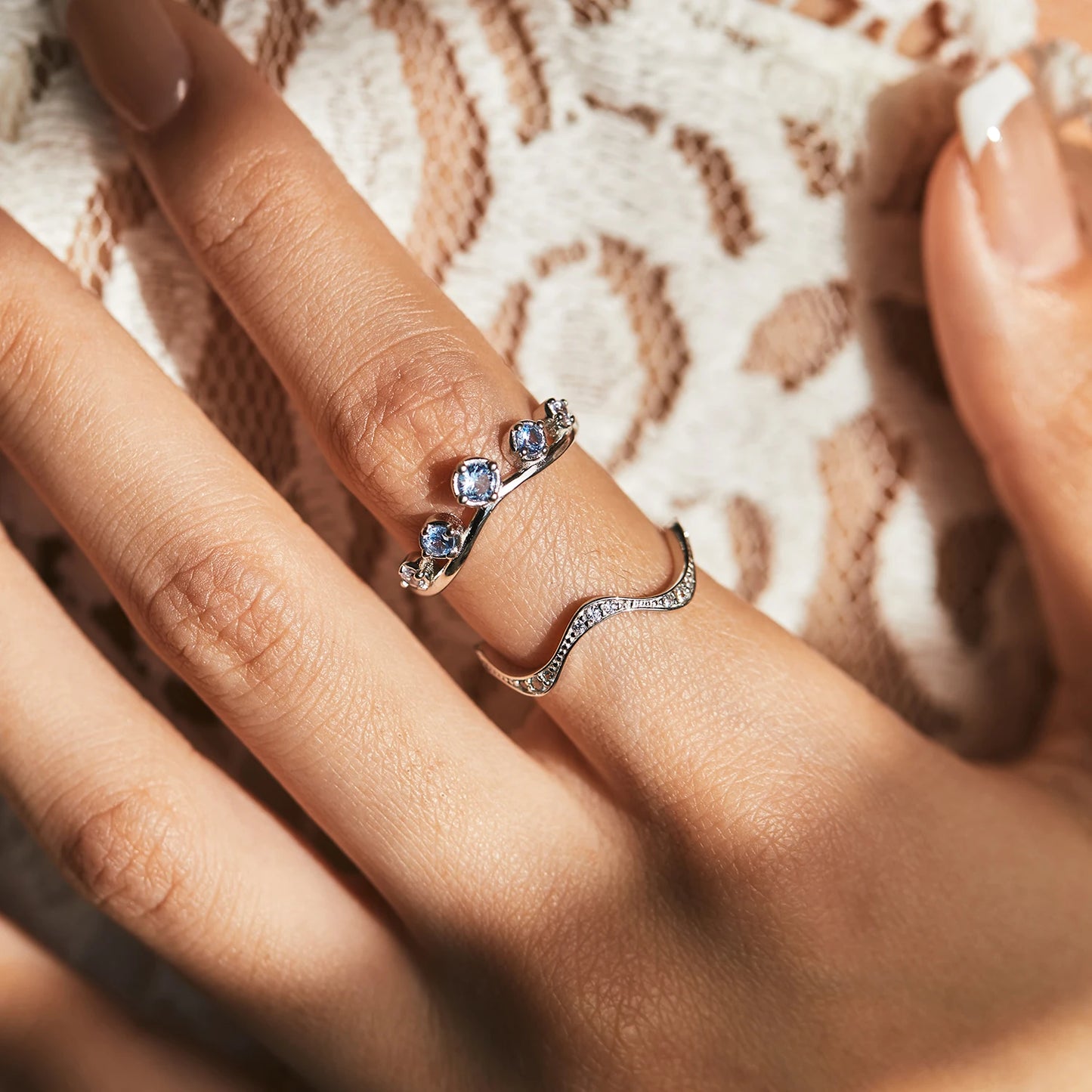 Sterling silver ring with six graduated light blue and lavender stones set in a tiara-like arc

