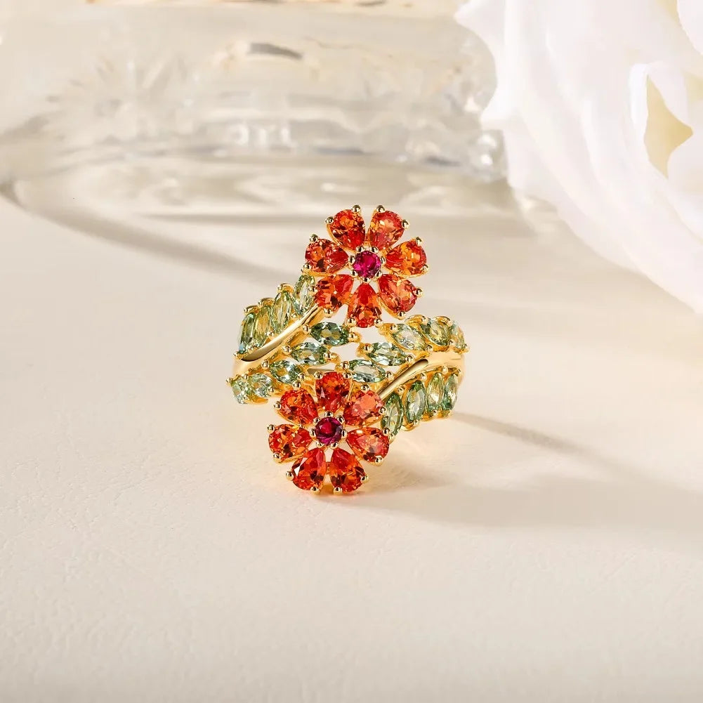 Gold ring with vibrant orange floral gemstones and soft green leaf-shaped stones, Fiore di Cristallo from the Rossa Collection.

