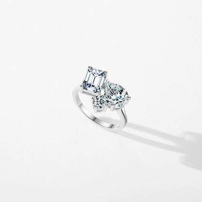 Silver ring with a mix of emerald, pear, and round-cut clear stones in an asymmetrical setting

