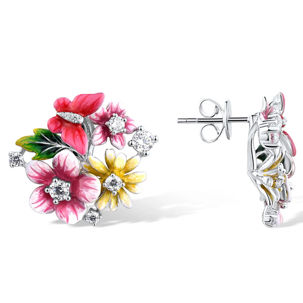 Pair of vibrant floral stud earrings with pink, red, and yellow enamel flowers accented by sparkling stones, set against a red background.

