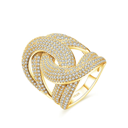 Wide silver ring with interlocking ribbon-like loops, entirely paved with sparkling white stones.

