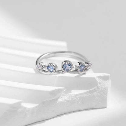 Sterling silver ring with six graduated light blue and lavender stones set in a tiara-like arc

