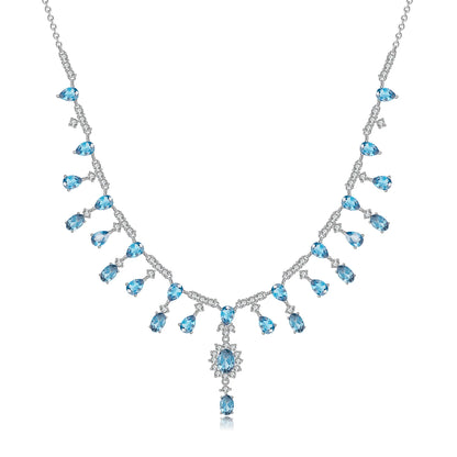 A silver necklace featuring green garnet stones set in an oval pattern with additional small white stones on a link chain.
