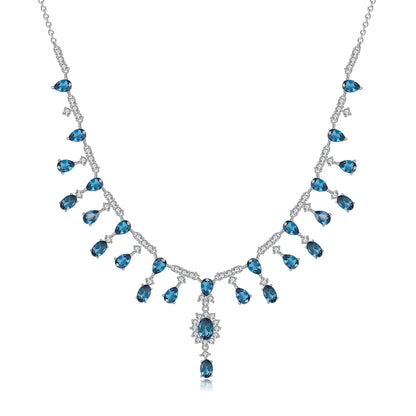 A silver necklace featuring green garnet stones set in an oval pattern with additional small white stones on a link chain.