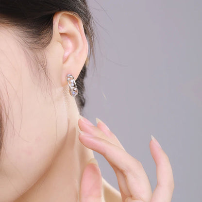 Silver hoop earrings with scattered opalescent and clear stones set in a textured band

