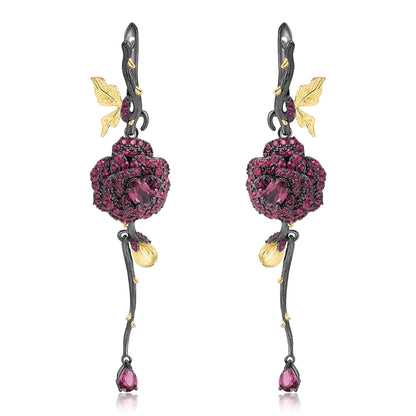 Long black rose earrings with red gemstones, gold leaves, and bud details from the Rossa Collection.

