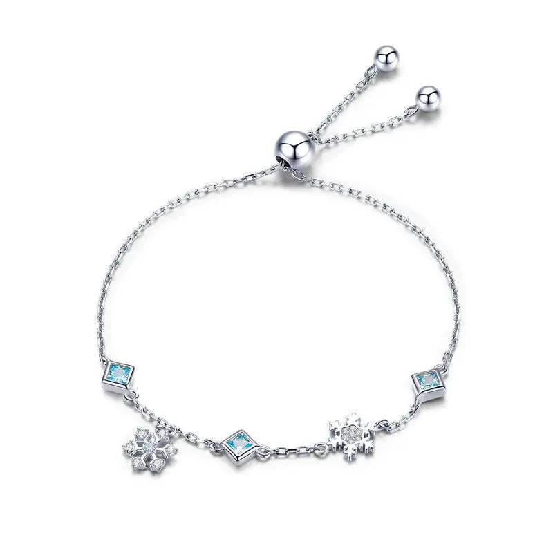 Delicate silver adjustable bracelet with blue square-cut stones and snowflake charms

