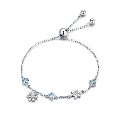 Delicate silver adjustable bracelet with blue square-cut stones and snowflake charms

