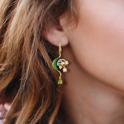 Gold drop earrings with curved green enamel leaves and cascading pink floral buds accented by pavé stones and teardrop gems

