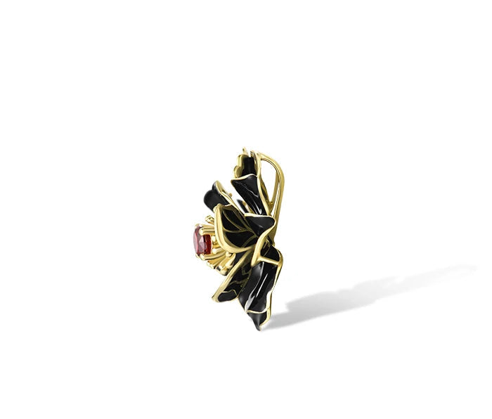 Jewelry set with black enamel floral design and red gemstone center, including a ring, earrings, and pendant.

