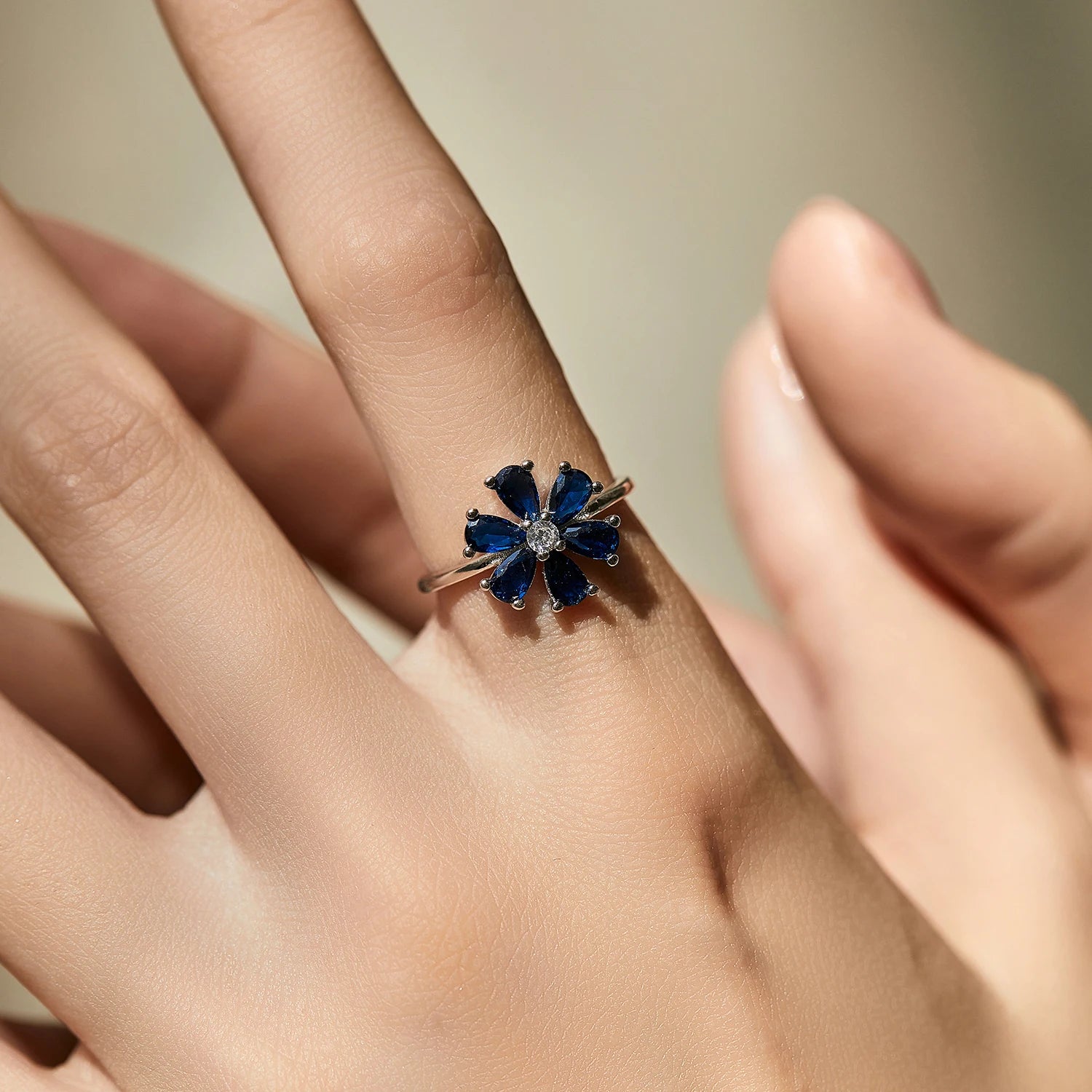 Sterling silver ring with a royal blue gemstone flower and clear stone center

