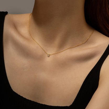 Gold chain necklace featuring a pear-shaped deep blue gemstone in a bezel setting