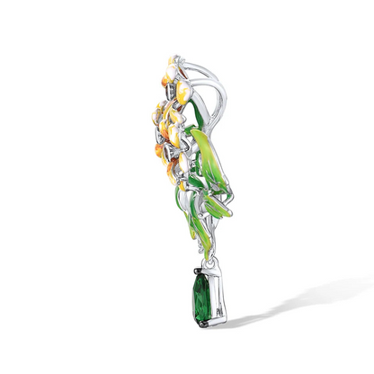 Brooch with three yellow enamel flowers, green enamel leaves, and a dangling green teardrop gemstone

