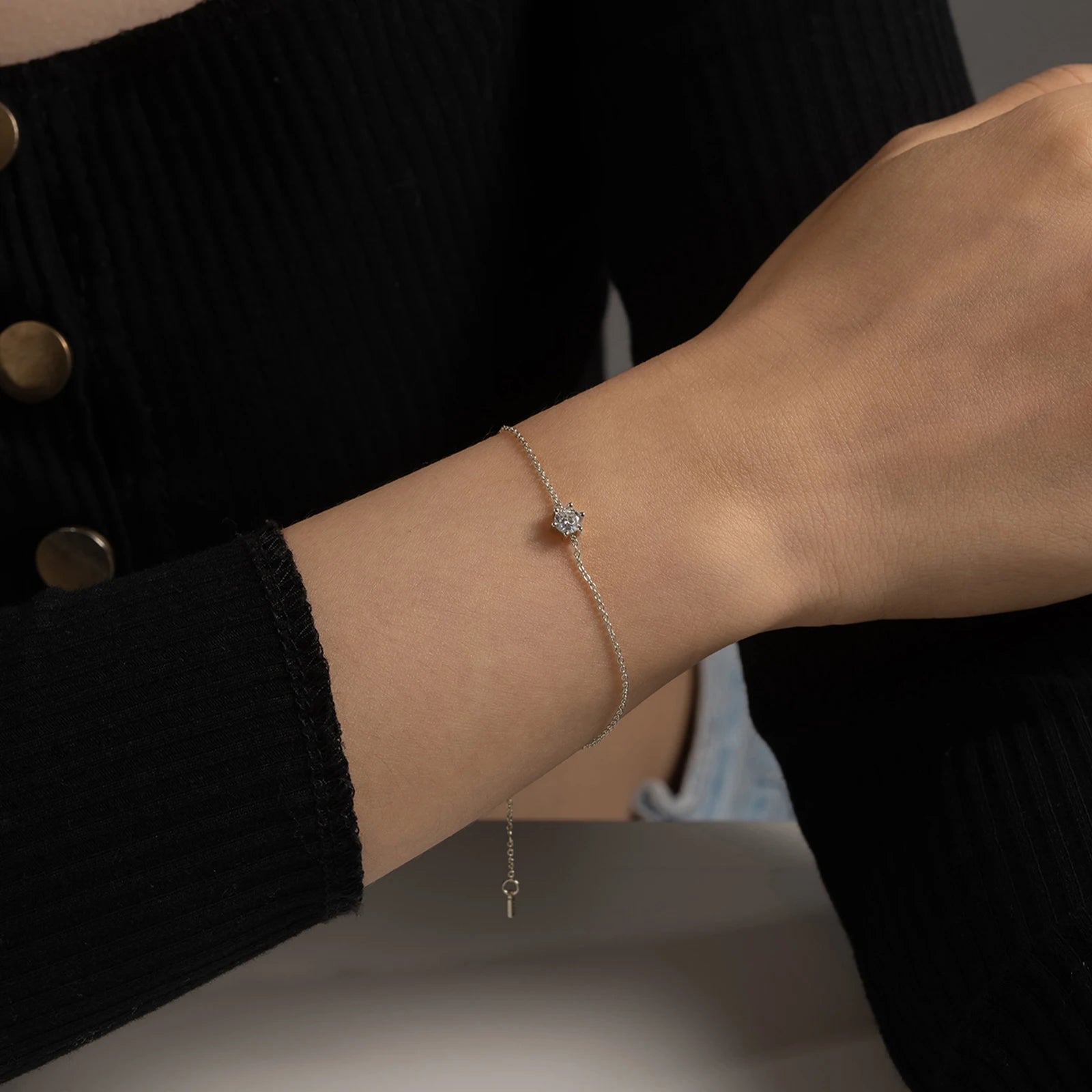 Delicate silver chain bracelet with a single round deep blue gemstone in a minimalist prong setting
