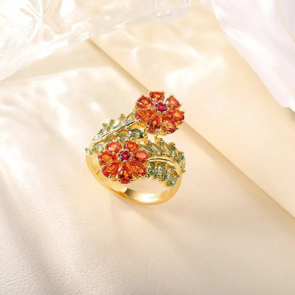 Gold ring with vibrant orange floral gemstones and soft green leaf-shaped stones, Fiore di Cristallo from the Rossa Collection.


