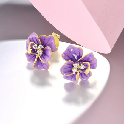 Gold floral stud earrings with violet enamel petals and crystal accents


