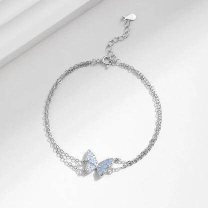 Delicate silver bracelet with a central opal butterfly charm and fine double chain

