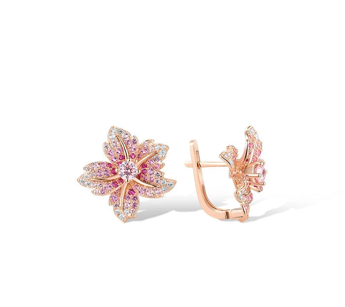 Rose gold floral earrings shaped like lilies, adorned with pink and clear pavé stones.

