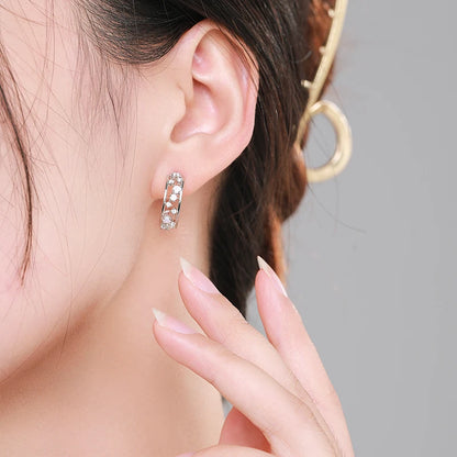 Silver hoop earrings with scattered opalescent and clear stones set in a textured band

