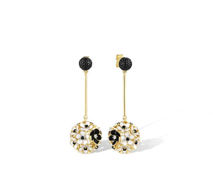 Fiore Scuro jewelry set featuring gold-tone earrings, ring, and pendant with white and black floral detailing from the Bianco Nero collection.

