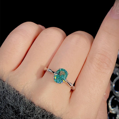 Green oval-cut gemstone ring with a polished silver band and four-prong setting

