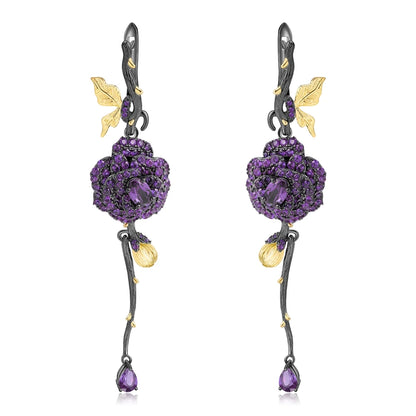 Long black rose earrings with red gemstones, gold leaves, and bud details from the Rossa Collection.


