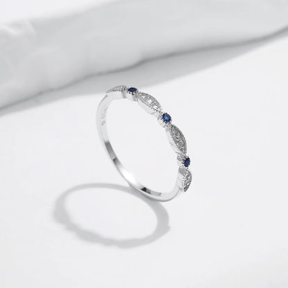 Sterling silver band with alternating marquise shapes and small round blue and clear stones

