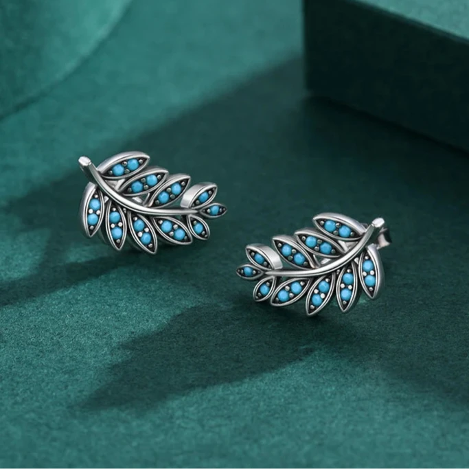 Silver feather-shaped stud earrings with vibrant turquoise enamel inlay

