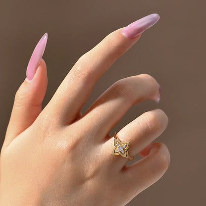 Hand wearing a gold ring with a diamond design on a brown background