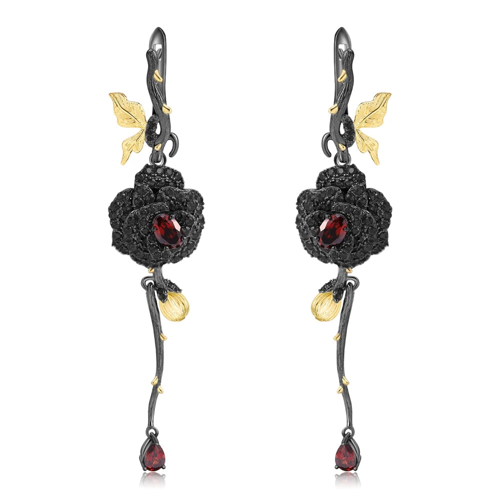Long black rose earrings with red gemstones, gold leaves, and bud details from the Rossa Collection.


