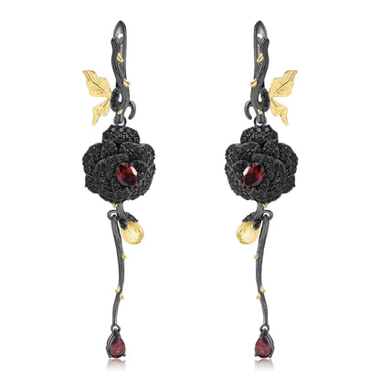 Long black rose earrings with red gemstones, gold leaves, and bud details from the Rossa Collection.

