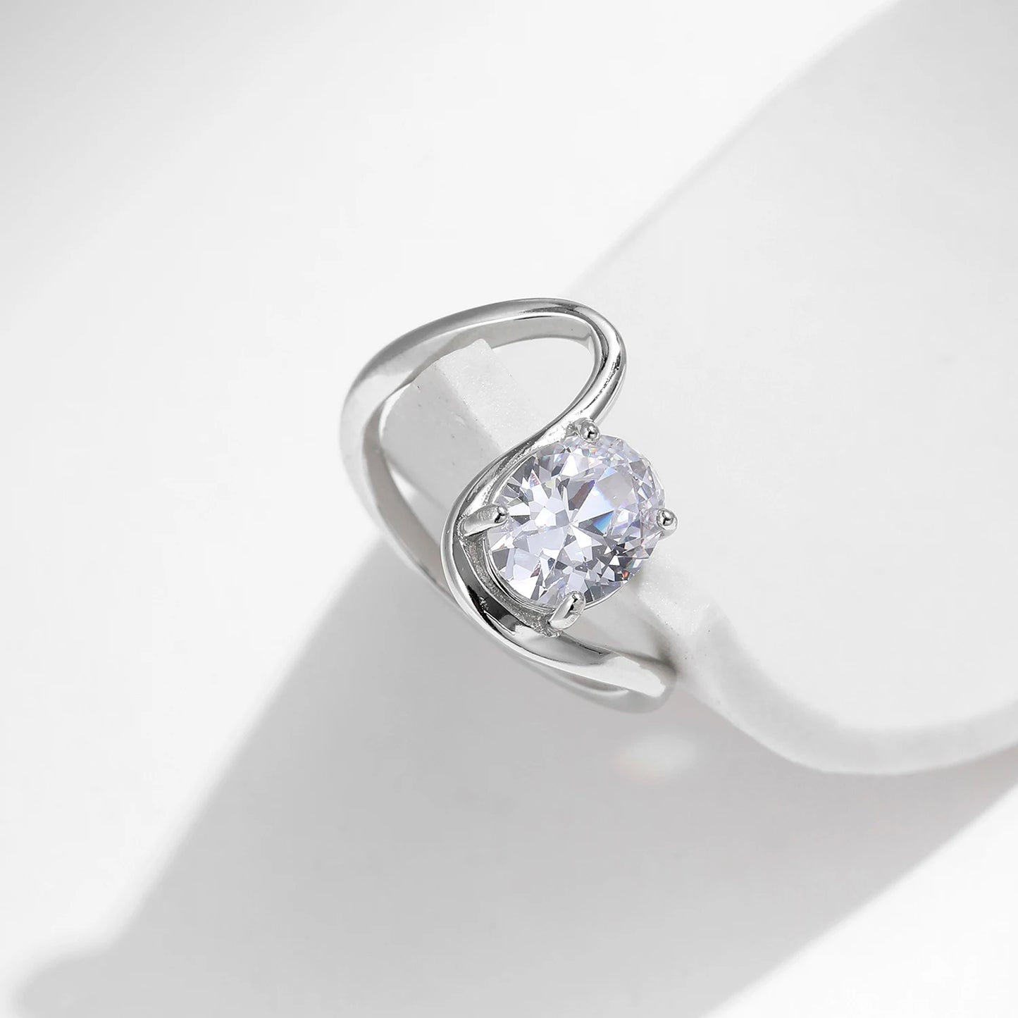 Open silver ring with a triangular wrap design, featuring a prominent oval white stone at its center, from the Bianco Nero collection.

