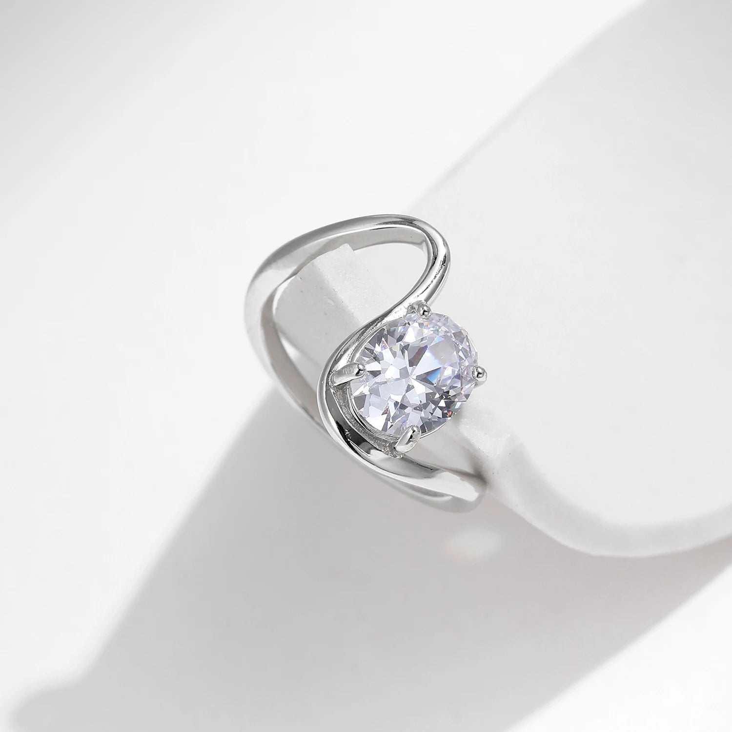 Open silver ring with a triangular wrap design, featuring a prominent oval white stone at its center, from the Bianco Nero collection.

