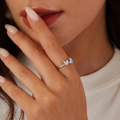 Delicate silver ring with pink and blue enamel butterflies and small white stones

