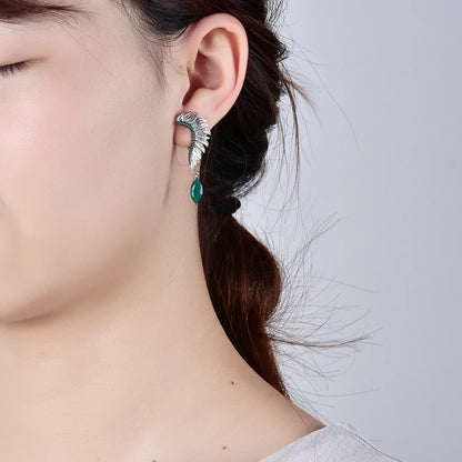 Silver earrings with feather-like design, green gemstones, and marquise green dangles

