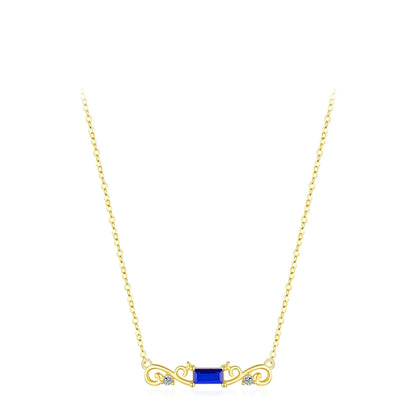 Gold necklace with a central rectangular deep blue gemstone flanked by scroll-like gold accents and small clear crystals