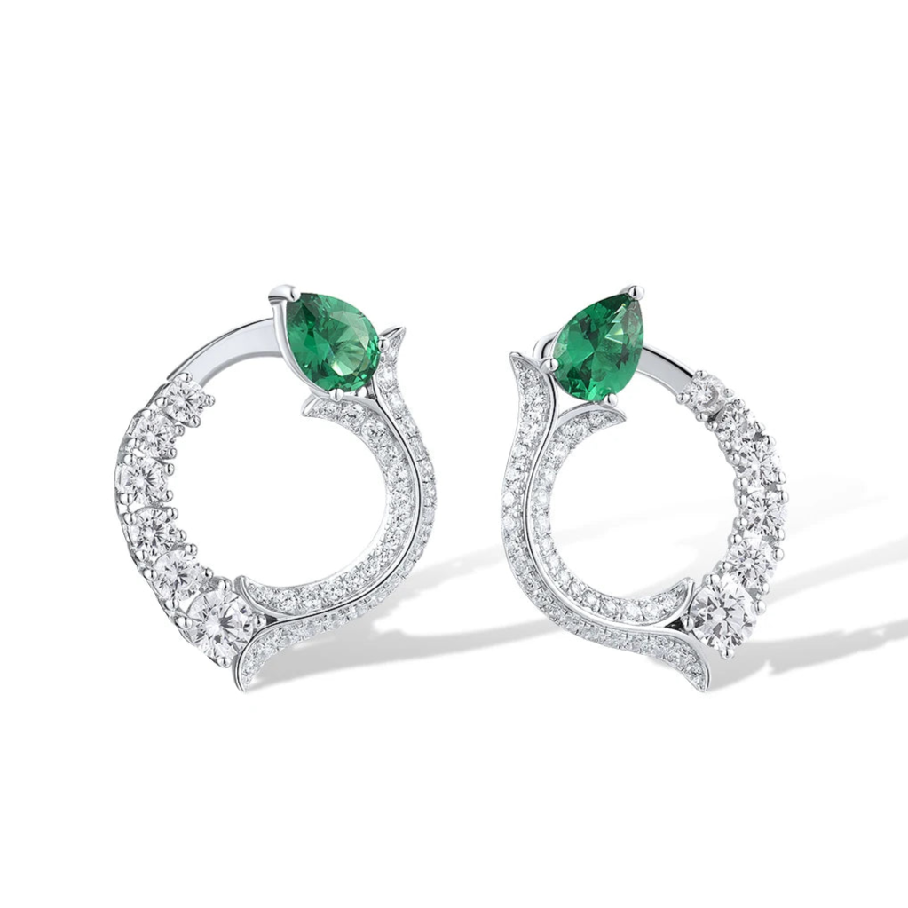 Silver earrings with circular diamond pave design and pear-shaped green jade stones at the top


