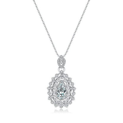 Ornate silver necklace with an intricate teardrop pendant, featuring a central pear-cut white gemstone, part of the Bianco Nero collection.


