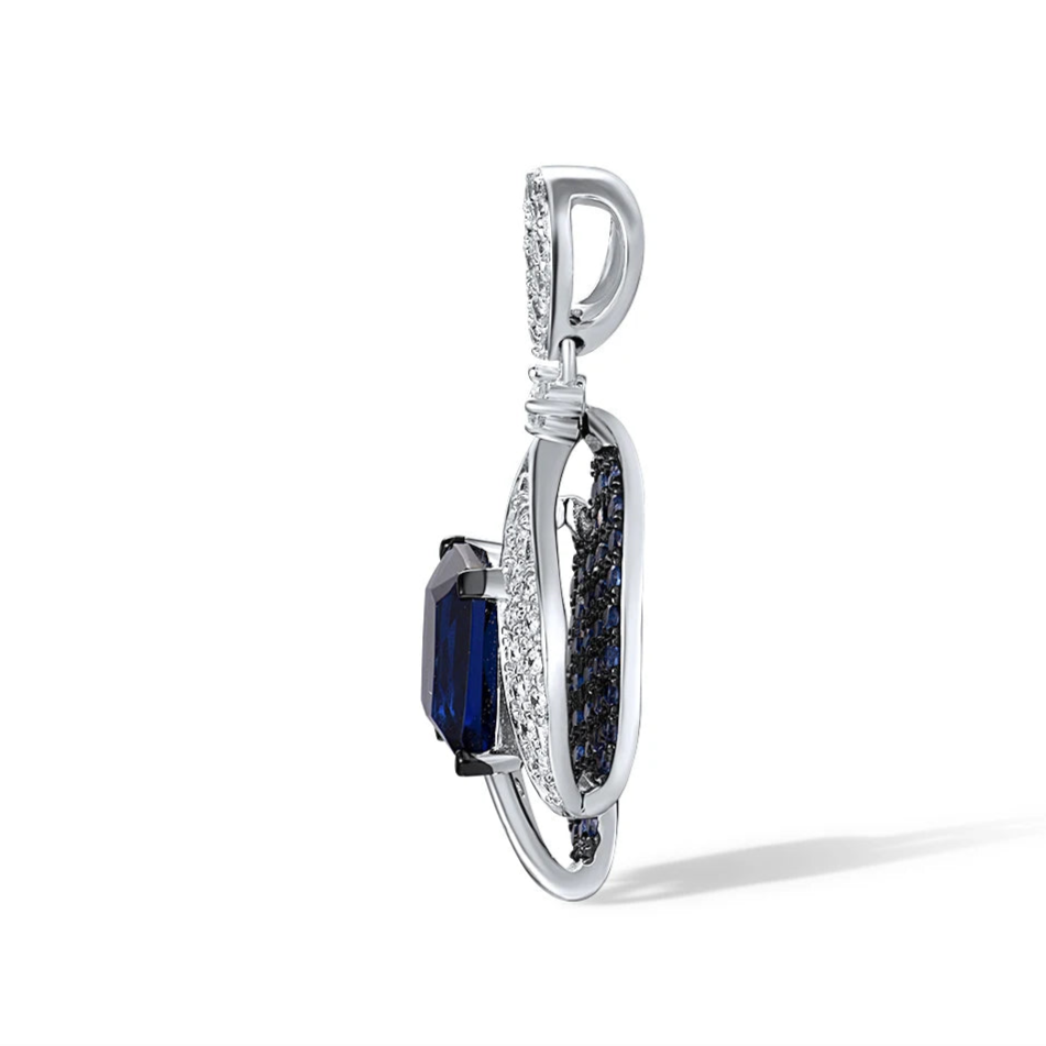 Sterling silver pendant with a rectangular dark blue gemstone surrounded by curving pavé-set bands and clustered blue stones