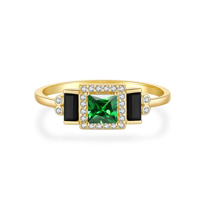 Gold ring with square green center stone, black accents, and pavé border

