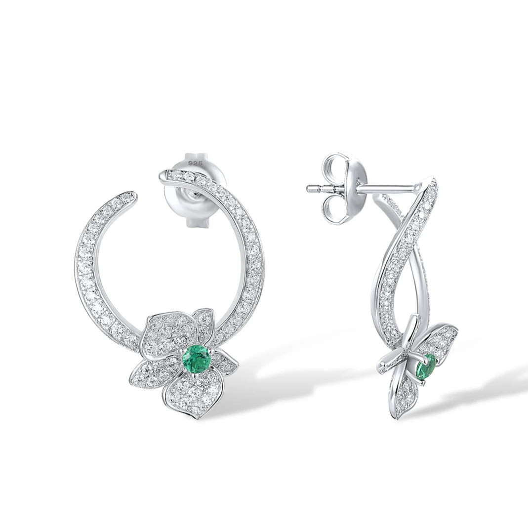 Silver stud earrings with open circle design, pavé stones, and green gemstone floral accents

