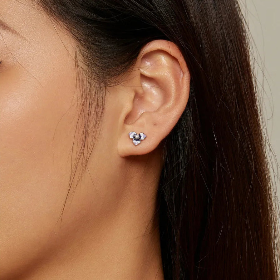 Sterling silver stud earrings shaped like purple enamel orchid flowers with a clear round gemstone at the center
