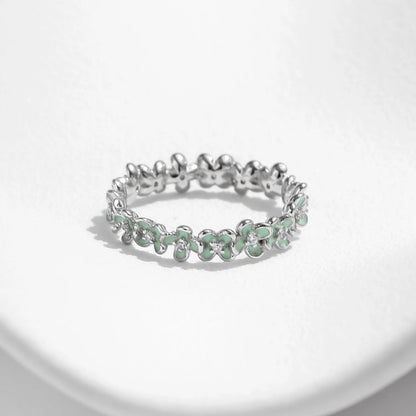 Sterling silver floral band ring with light green enamel petals and tiny diamond accents.

