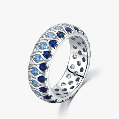 Sterling silver eternity band with alternating light and dark blue stones in a woven design

