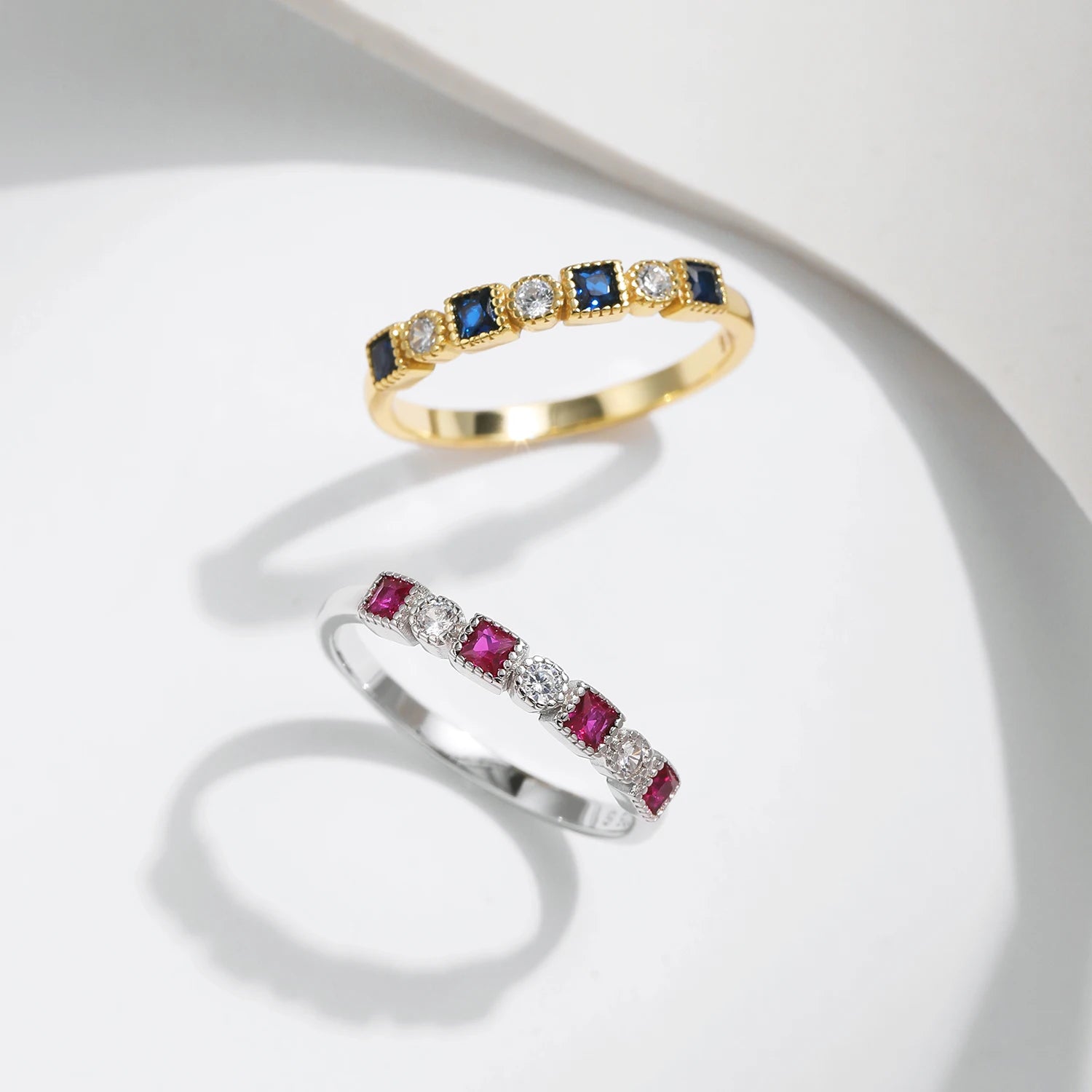 Gold ring with alternating square blue stones and round clear stones
Sterling silver ring with alternating square-cut red stones and round clear stones in a linear setting.



