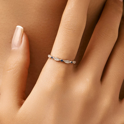 Sterling silver band with alternating marquise shapes and small round blue and clear stones


