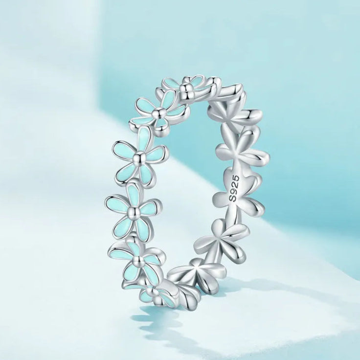 Silver floral band ring with alternating blue enamel and plain silver daisy motifs

