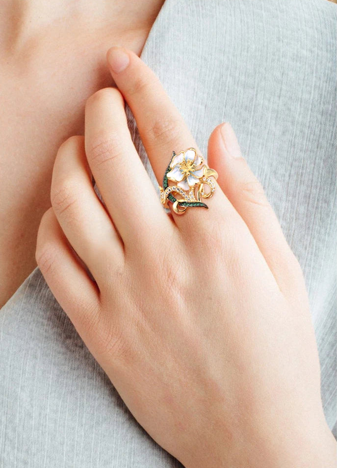 Nastro Verde jewelry set with green-accented gold-tone earrings and ring featuring delicate white flowers from the Verde collection.

