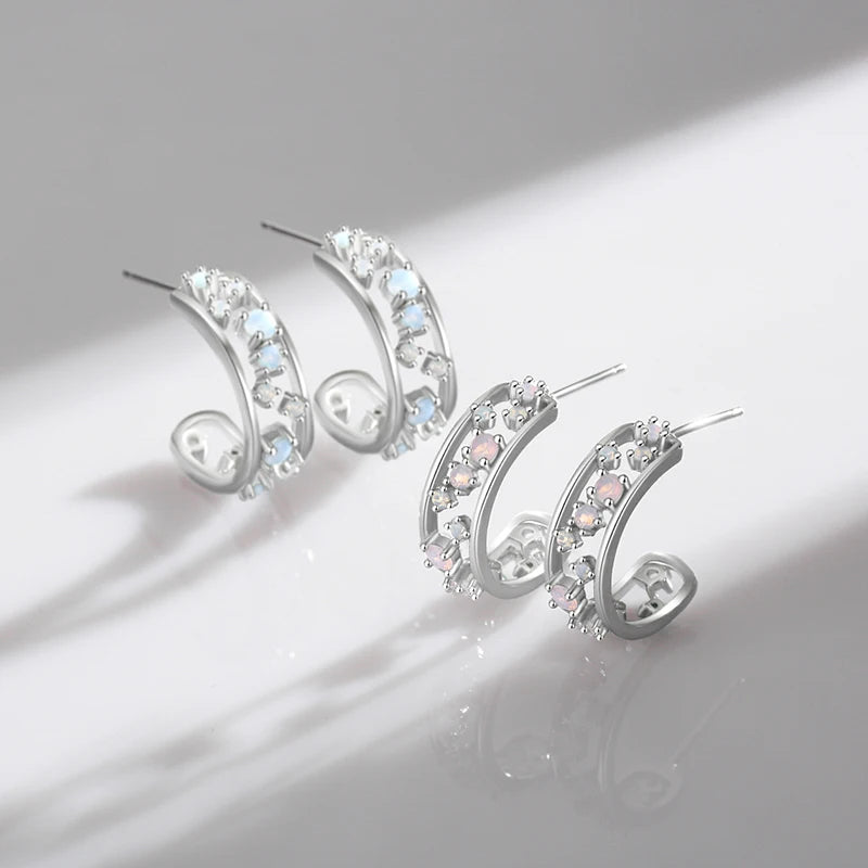 Silver hoop earrings with scattered opalescent and clear stones set in a textured band

